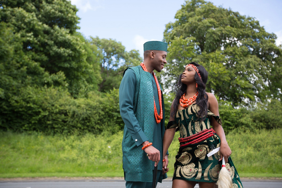 Bride and groom in traditional Nigerian clothing looking at each other